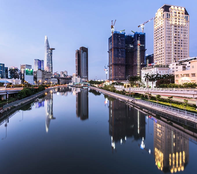 Stunning reflection of skyscraper and tall residential buildings on the Saigon river at twilight in Ho Chi Minh City, Vietnam largest city.